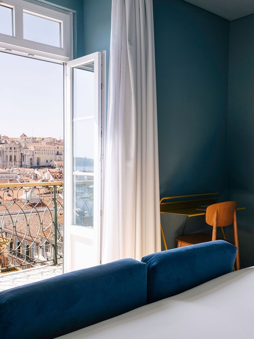 um quarto com uma janela aberta com vista para uma cidade