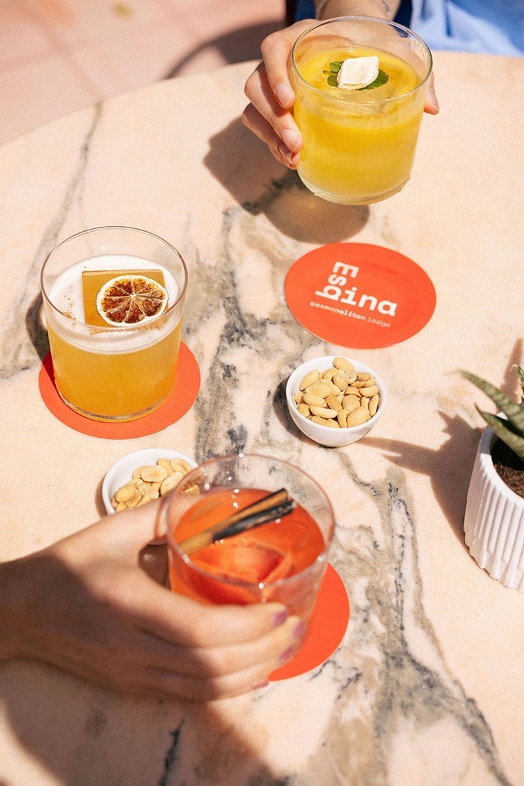 duas pessoas estão sentadas em uma mesa segurando bebidas