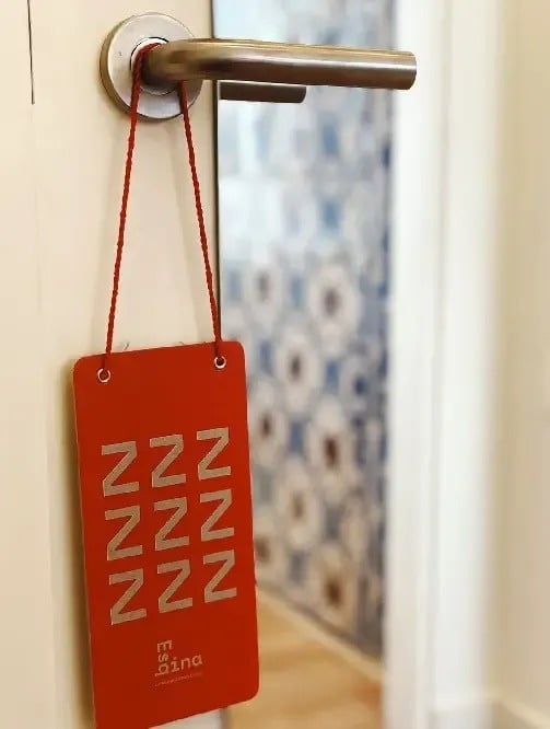 una tarjeta roja colgada de una manija de puerta .