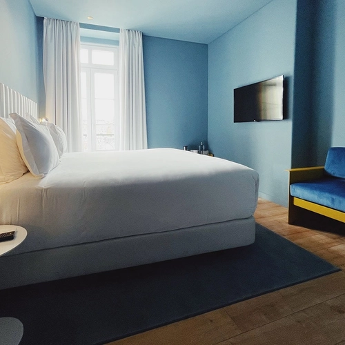 a hotel room with a bed and a blue couch