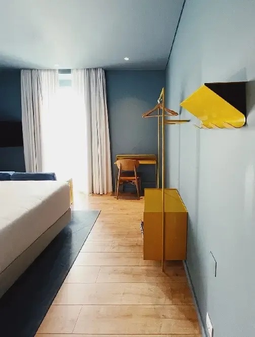 a hotel room with a bed , desk and chairs
