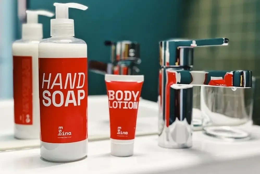 una botella de jabón de manos junto a una botella de loción corporal