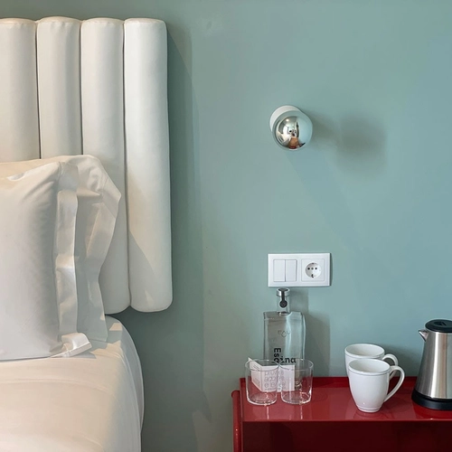 a bed with a white headboard and a red nightstand