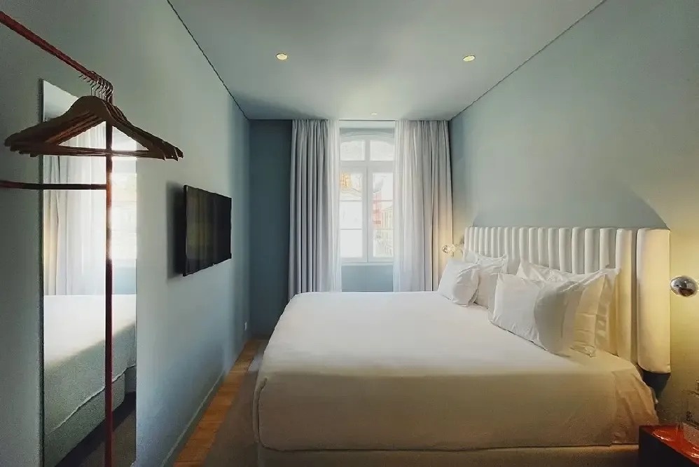 una habitación con una cama y una televisión en la pared