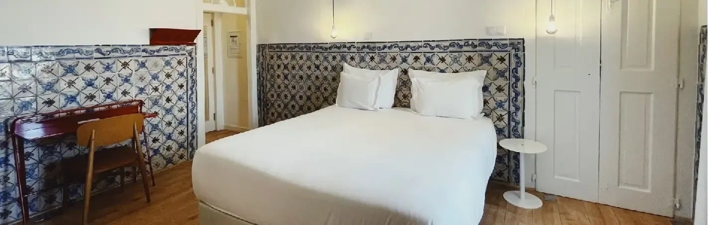 a bedroom with blue and white tiles and a bed