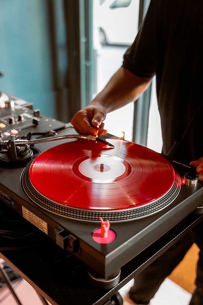 DJ mezclando vinilo rojo vibrante en Esqina: Cosmopolitan