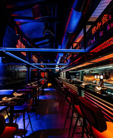 a woman sits at a table in a restaurant with a laptop