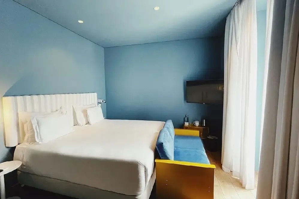 a hotel room with a large bed and a yellow couch