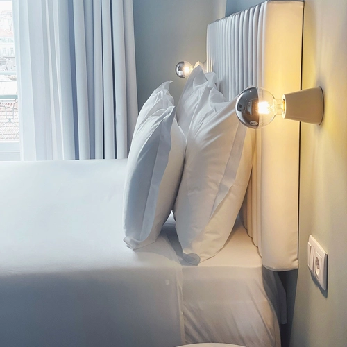 a remote control sits on a small table next to a bed
