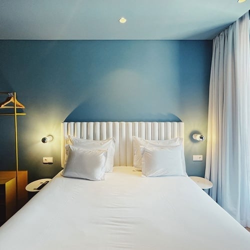 a hotel room with a bed and blue walls