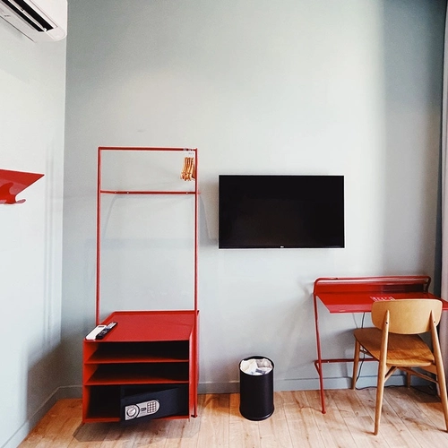a room with a red desk and chair and a flat screen tv