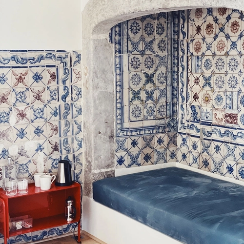 a room with blue and white tiles and a bed
