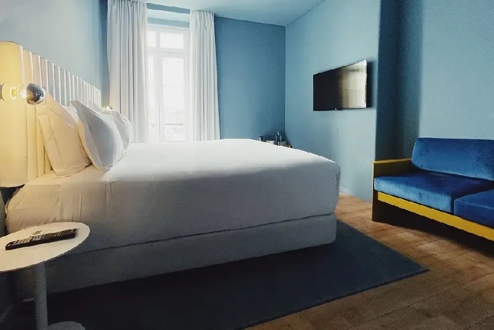 a hotel room with a bed and a blue couch