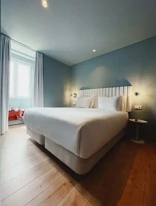 a hotel room with a king size bed and wooden floors
