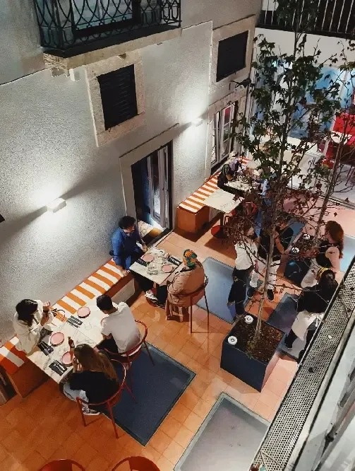 a group of people sit at tables in a restaurant