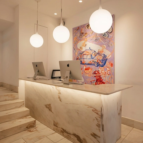 a reception desk with two apple computers on it