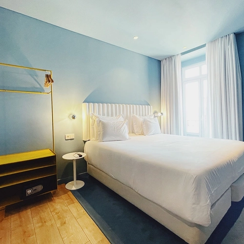 a hotel room with a king size bed and blue walls