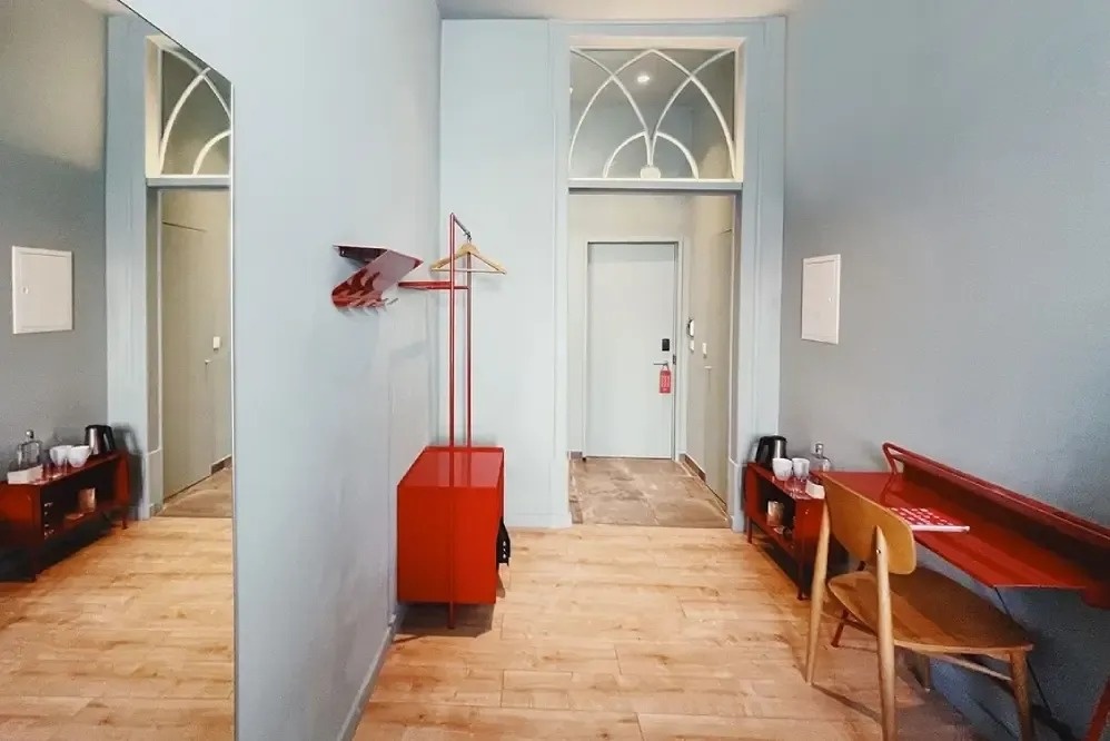 a hallway with a red desk and a red chair