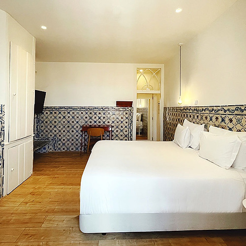 a bedroom with blue and white tiles and a bed