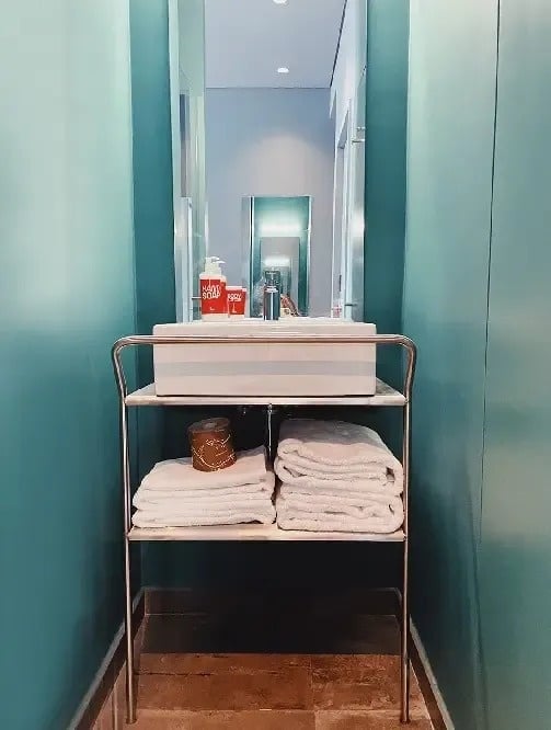 a bathroom with a sink , towels and a mirror .