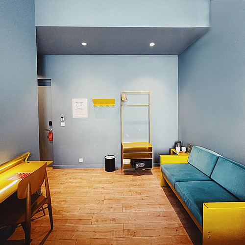 a room with blue walls and a yellow couch