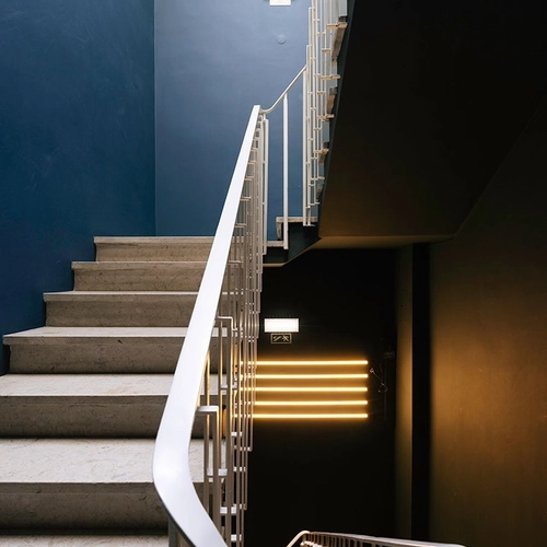 a staircase with a blue wall and a white railing