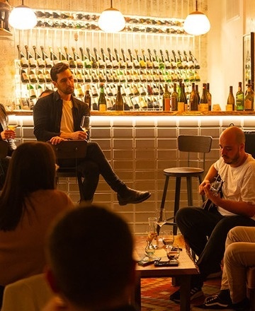 a woman sits at a table in a restaurant with a laptop