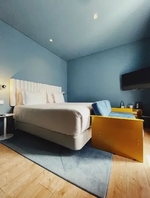 a hotel room with a bed , couch and television .