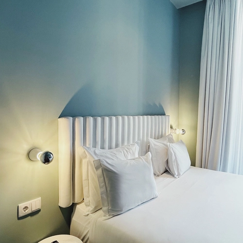 a hotel room with a bed and a remote on a nightstand
