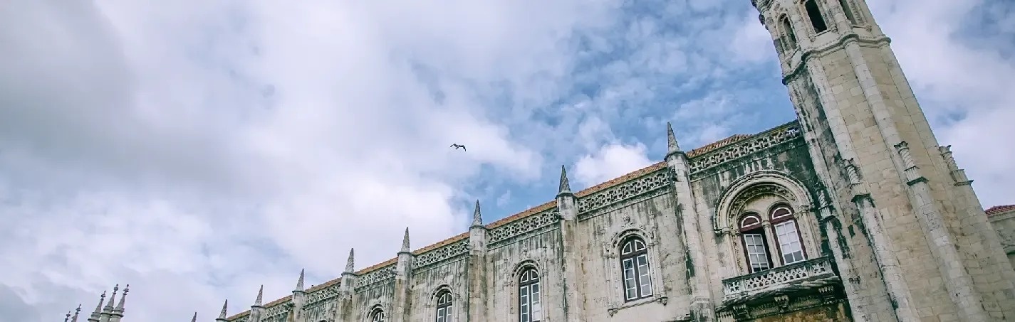 a bird is flying over a large building with a blue sky in the background