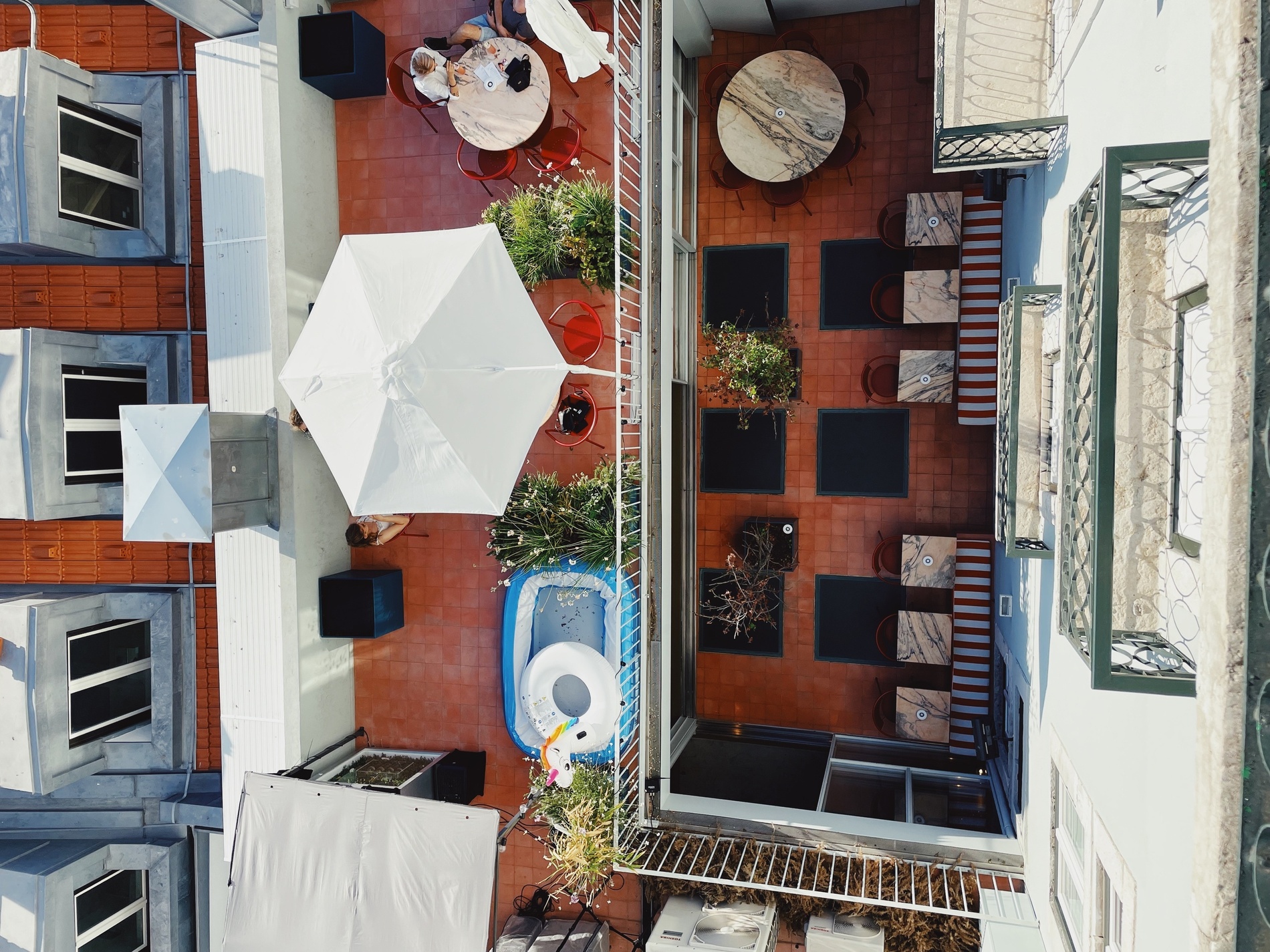 una vista aérea de un balcón con mesas y sombrillas