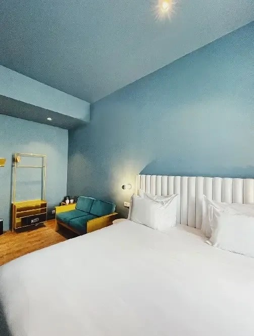 a hotel room with a bed , couch , and blue walls .