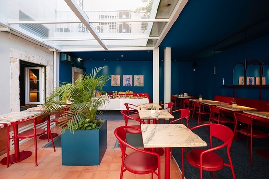 a restaurant with blue walls and red chairs