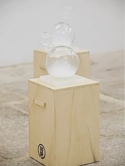 a glass sculpture is sitting on top of a wooden box .