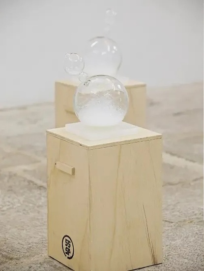 a glass sculpture is sitting on top of a wooden box .