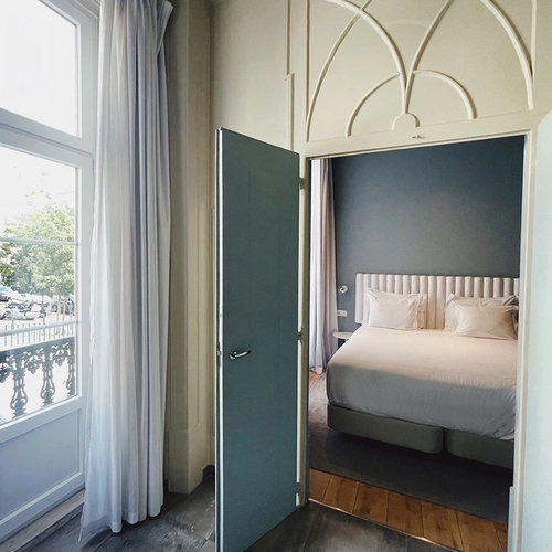 a bedroom with a bed and a large window