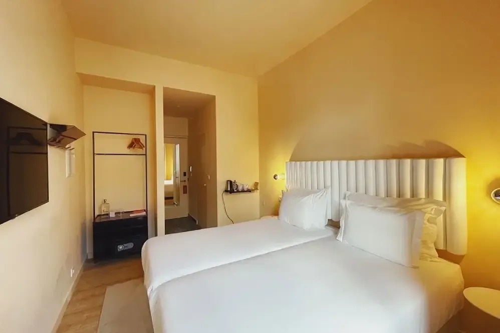 una habitación de hotel con dos camas y una televisión