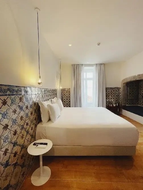 una habitación de hotel con una cama king size , una mesa y una chimenea .