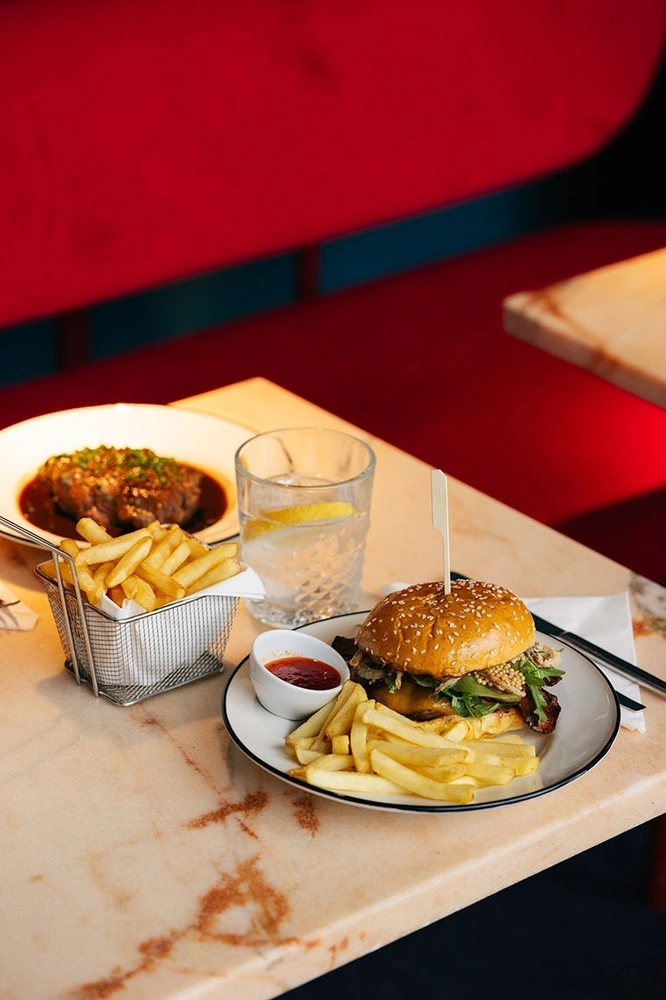 un plato de hamburguesa y papas fritas en una mesa