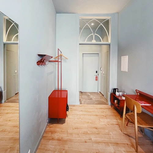 a hallway with a red desk and a red chair