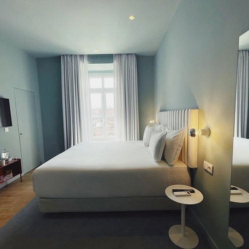 a hotel room with a large bed and a mirror
