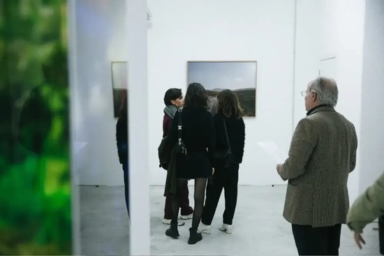 a group of people are looking at a painting in an art gallery