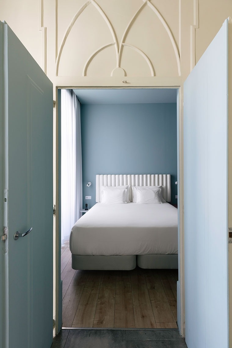 a bedroom with blue walls and a white bed