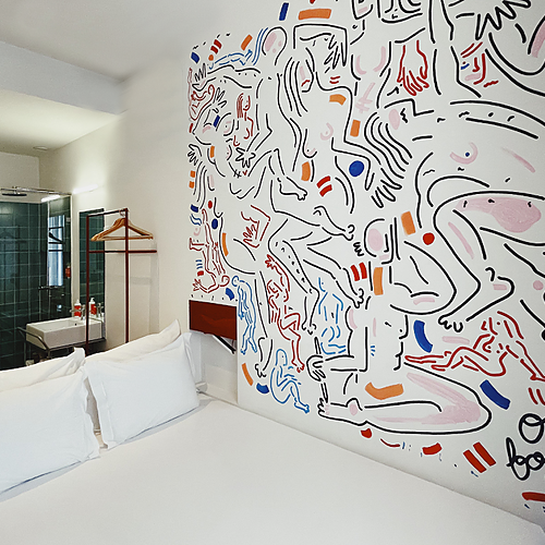 a bedroom with a painting on the wall that says open for love