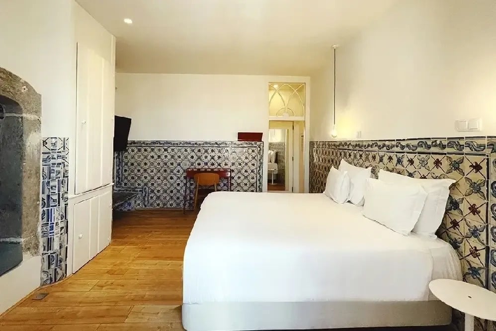 a bedroom with blue and white tiles and a large bed