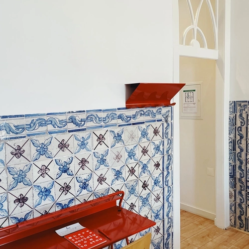 a red desk with blue and white tiles behind it