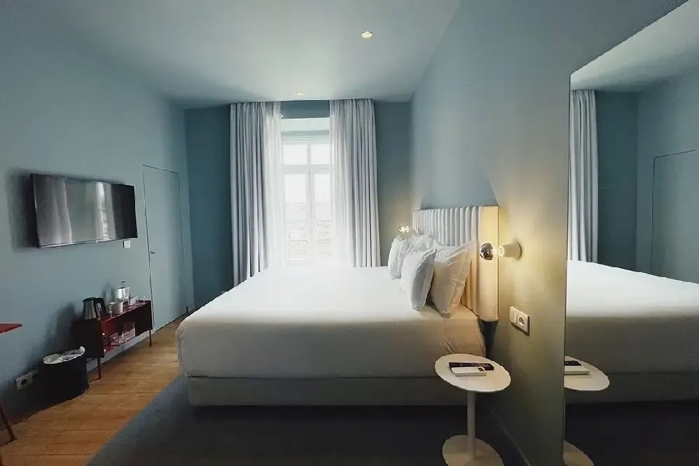 a hotel room with a large bed and a large mirror