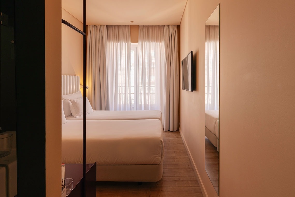 a hotel room with two beds and a safe