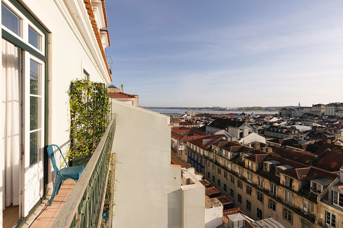 a view of a city from a balcony with a blue chair