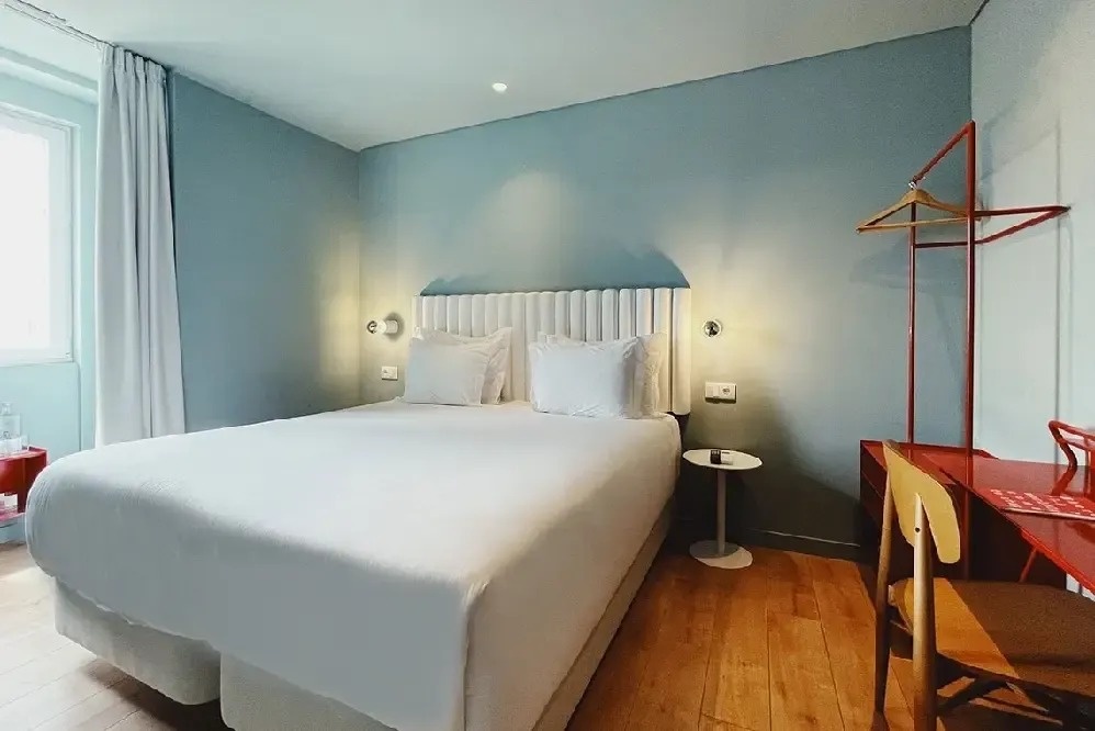 una habitación de hotel con una cama y una mesa roja